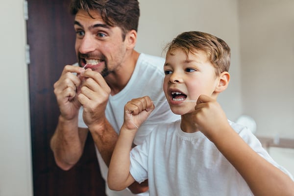 father and son flossing teetch